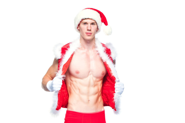 Sexy Santa Claus . Young muscular man wearing Santa Claus hat demonstrate his muscles. Isolated on white background. - Photo, Image