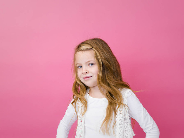 portrait of pretty girl in white clothes smiling and looking at camera on pink background  - Foto, Imagem