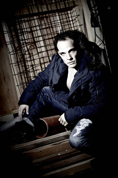 portrait of handsome male model in warm  jacket posing on dark studio background  - Фото, изображение