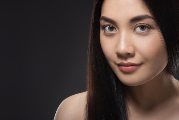 portrait of pretty asian woman with healthy and strong hair isolated on black - Photo, Image