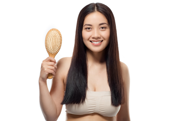 retrato de sonriente hermosa mujer asiática con cepillo de pelo aislado en blanco
 - Foto, Imagen