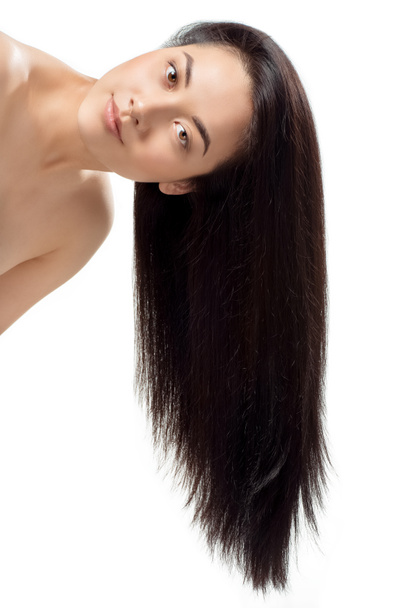 Porträt eines attraktiven asiatischen Models mit kräftigem und gesundem Haar, das die Kamera isoliert auf Weiß betrachtet - Foto, Bild