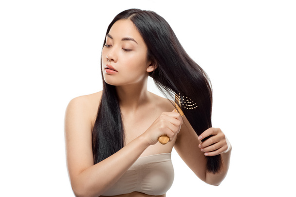 πορτρέτο του όμορφη γυναίκα της Ασίας βούρτσισμα των μαλλιών που απομονώνονται σε λευκό - Φωτογραφία, εικόνα