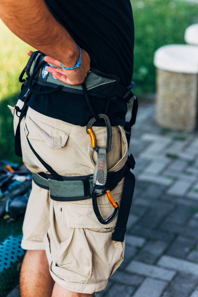 escalador de rocha vestindo chicotes de segurança e equipamento de escalada ao ar livre
 - Foto, Imagem