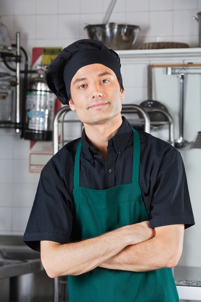 mužský kuchař s rukama zkříženýma v kuchyni - Fotografie, Obrázek