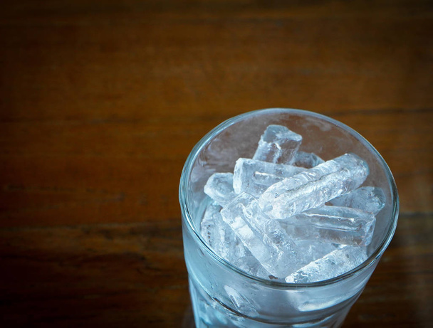 Ice cubes in glass on a wooden dark background. - Fotó, kép