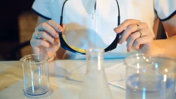 Woman scientist mixing together two liquid substances. Scientific discoveries. - Video