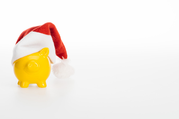 gelbe Sparschwein in Weihnachtsmütze isoliert auf weißem Hintergrund - Foto, Bild