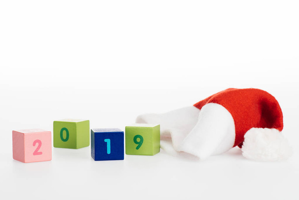 close-up view of 2019 symbol on cubes and santa hat isolated on white - Foto, Bild