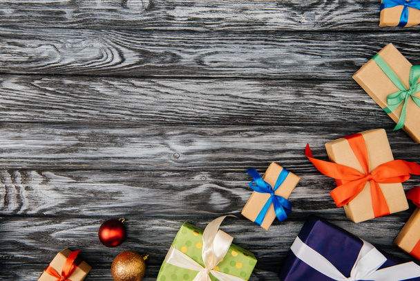 top view of christmas gifts and shiny baubles on wooden surface - 写真・画像