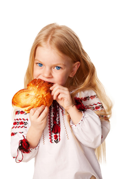 μικρό κορίτσι, τρώγοντας κουλούρι με μεγάλη όρεξη. - Φωτογραφία, εικόνα