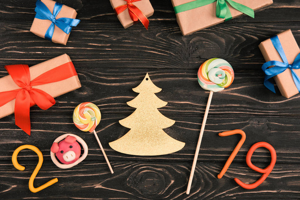 vue du dessus des sucettes, panneau 2019 et cadeaux de Noël sur la surface en bois
 - Photo, image