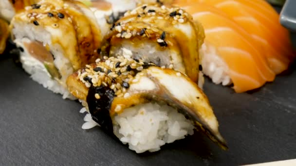 Sushi rolls v různé směsi na černém kamenn talífi - Záběry, video
