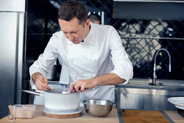 Cuoco di talento inventando un nuovo piatto insolito in cucina
 - Foto, immagini
