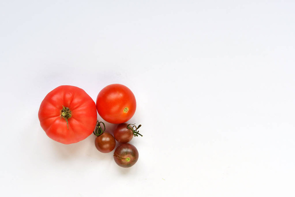 Autumn harvest. Large and small red tomatoes on a white background. - Foto, immagini
