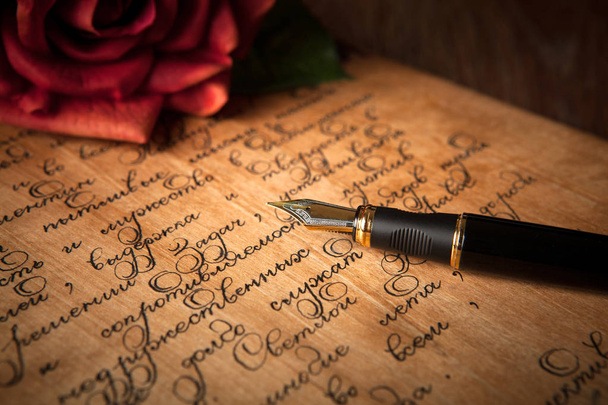 Füllfederhalter auf Brief mit Text und roter Rose in Großaufnahme - Foto, Bild