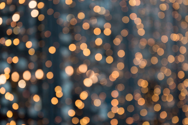 Christmas abstract background. Blurred golden garland blur bokeh, defocused pattern. - 写真・画像