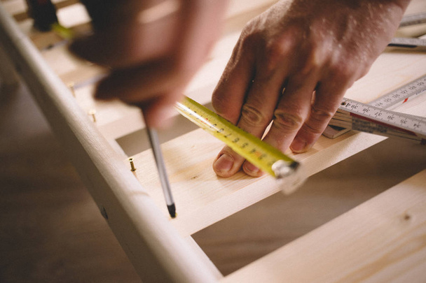 Detailní záběr rukou člověka, muže šrouby, šroubovák, instrukce a výstavby ruleta, montáž nábytku - Fotografie, Obrázek