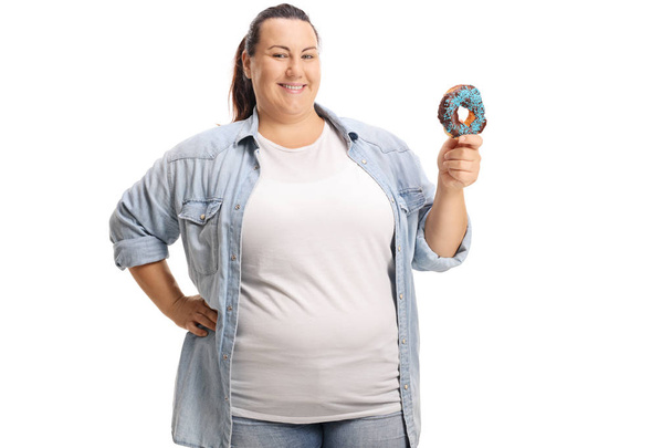 Smiling overweight woman holding a donut isolated on white background - Foto, imagen