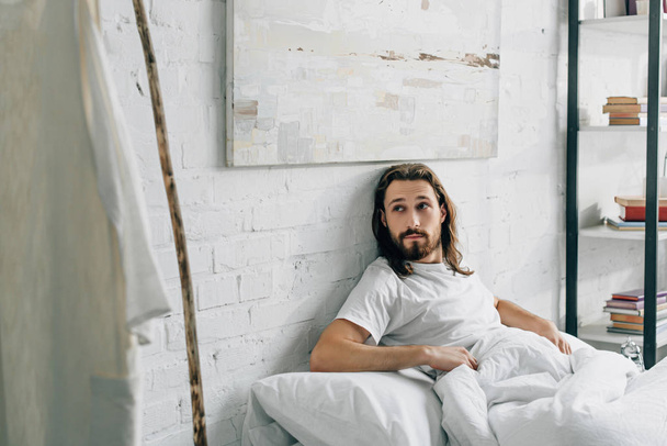 szelektív összpontosít Jézus ébredt fel az ágyban, és nézte a saját ruhámat és a fából készült személyzet otthon  - Fotó, kép