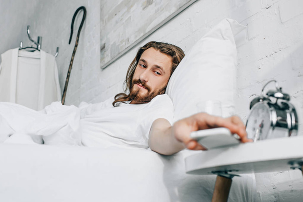 foyer sélectif de Jésus prenant smartphone dans la chambre à coucher à la maison
  - Photo, image