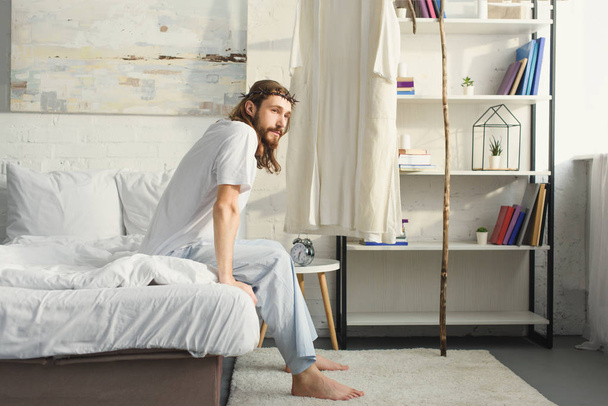 szelektív összpontosít Jézus hálószobás otthon reggel idő alatt ágyon ül - Fotó, kép