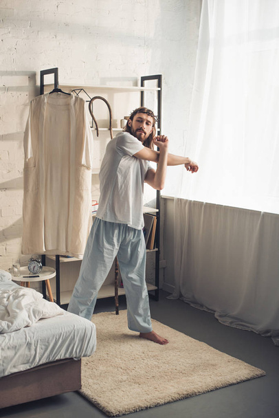 Jésus confiant dans la couronne d'épines faisant l'entraînement du matin dans la chambre à coucher à la maison
  - Photo, image