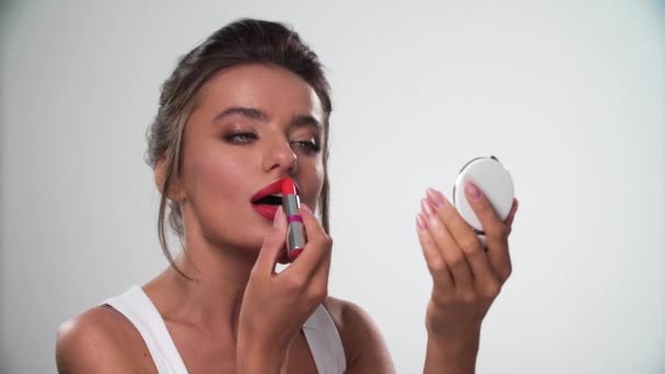 Lippen Make-up. schöne Frau trägt roten Lippenstift auf der Lippe auf - Filmmaterial, Video