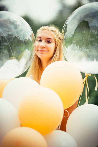 portrait of young girl with balloons on nature background. - Foto, Imagen