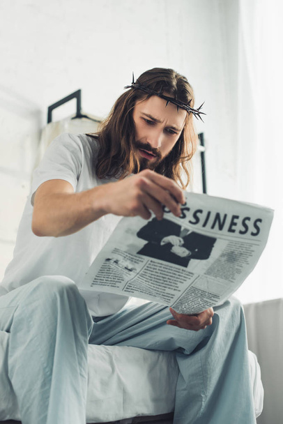 alacsony, szög, Kilátás Jézus a koronát a tövisek olvasó üzleti napilap, a hálószoba az időszakban reggel otthon - Fotó, kép