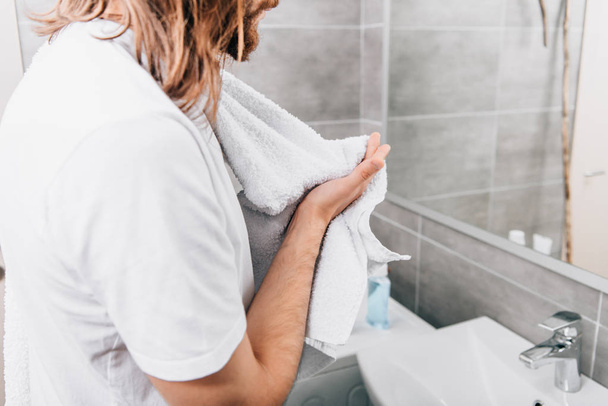 cropped image of Jesus with towel over shoulder wiping hands in bathroom  - Photo, Image