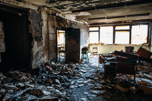 Интерьер сгоревшего дома. Горела комната в производственном здании, обгорела мебель и повреждена квартира после пожара
 - Фото, изображение