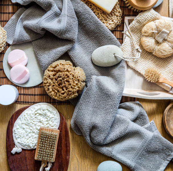 still life with many healthy body care and skincare objects - natural sponge, loofah, body and manicure brushes for traditional green beauty, top view - Fotó, kép
