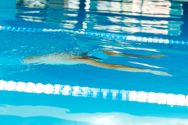 Photo of sports male swimming under water in pool - Fotó, kép