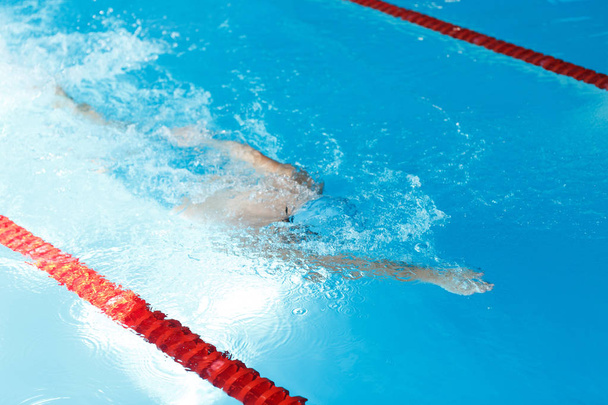 Photo of athlete man swimming under water in swimming pool - Foto, afbeelding