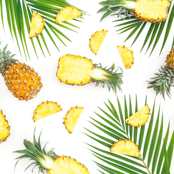 Тропический узор из плодов ананаса с пальмовыми листьями на белом фоне. Квартира лежала, вид сверху. Тропическая концепция
. - Фото, изображение