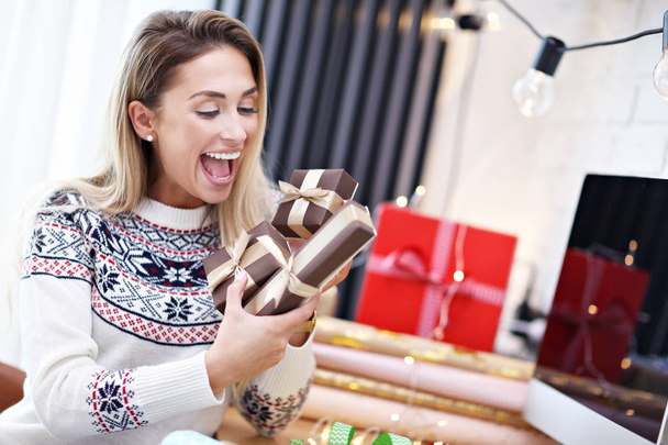 Adult woman at home wrapping Christmas presents - 写真・画像