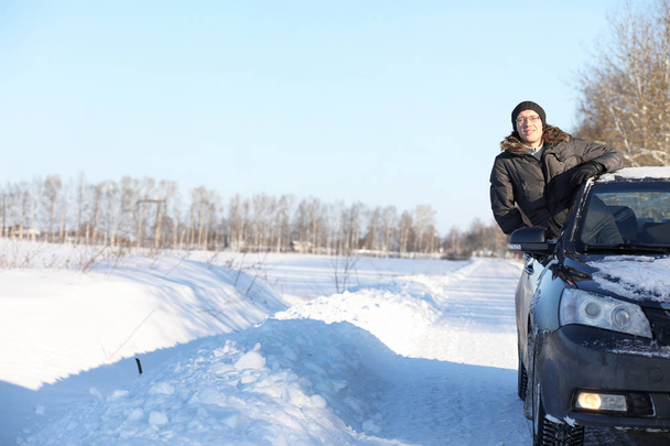 homem olha pela janela do carro na estrada coberta de neve
 - Foto, Imagem