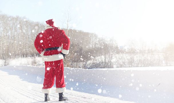 Der Weihnachtsmann kommt mit Geschenken aus dem Freien. Weihnachtsmann im roten Su - Foto, Bild