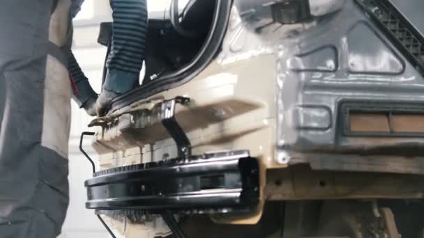 Mechanik sprawdza wiarygodność nadwozia samochodu w warsztat samochodowy - Materiał filmowy, wideo