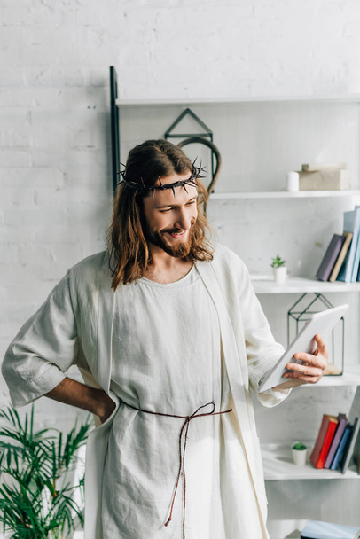 vidám Jézus koronája tövis és köntös használ digitális tábla otthon - Fotó, kép