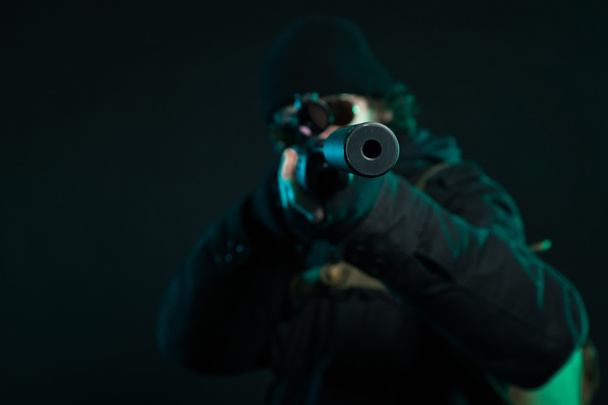 Francotirador con barba en pistola negra. Captura de estudio
. - Foto, imagen