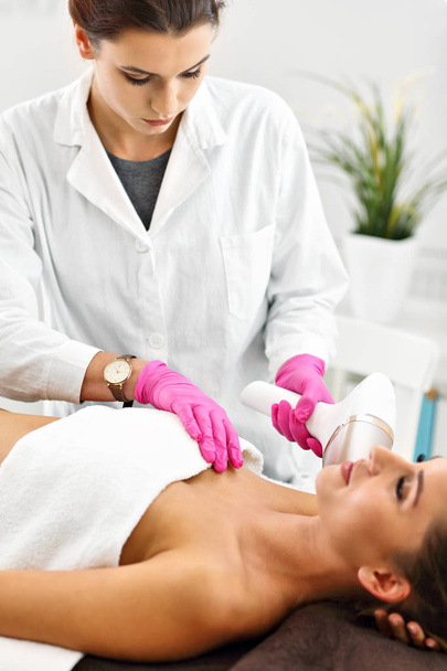 Adult woman having laser hair removal in professional beauty salon - Fotoğraf, Görsel