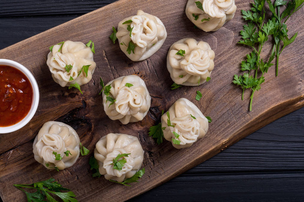 Georgian dumplings khinkali with tomato sauce and parsley - 写真・画像