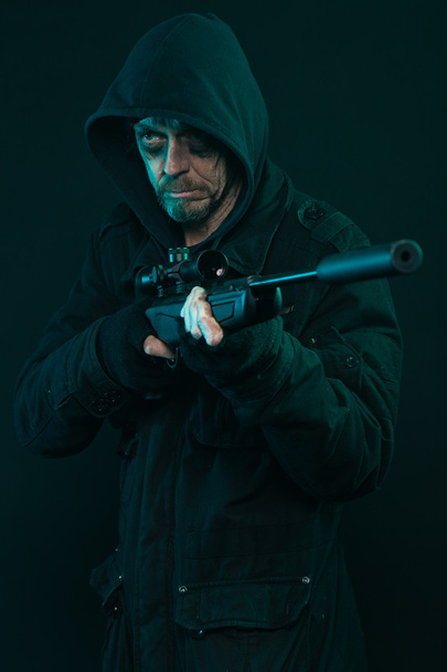 Sniper with beard in black holding gun. Studio shot. - Φωτογραφία, εικόνα