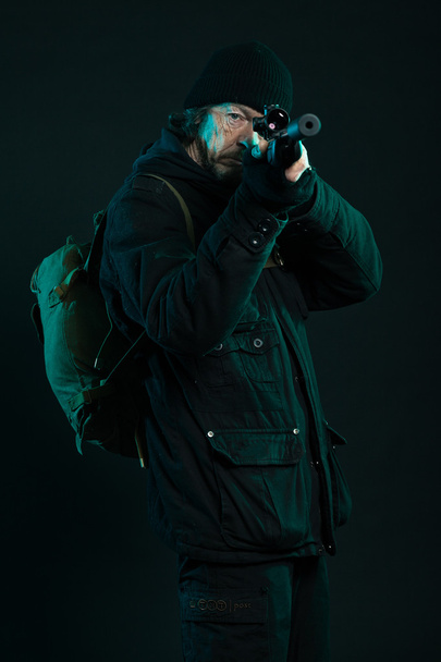 Sniper with beard in black holding gun. Studio shot. - Fotoğraf, Görsel