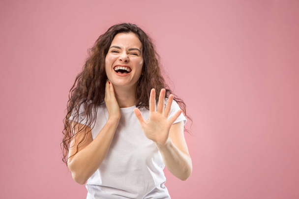The happy business woman standing and smiling against pink background. - Photo, Image