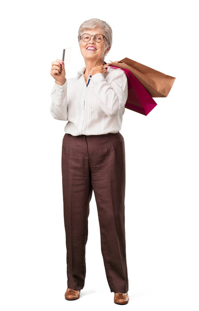 Plné tělo starší žena veselá a usmíval se, velmi nadšený, nové bankovní kartu a nákupní tašky, jste připraveni jít nakupovat - Fotografie, Obrázek