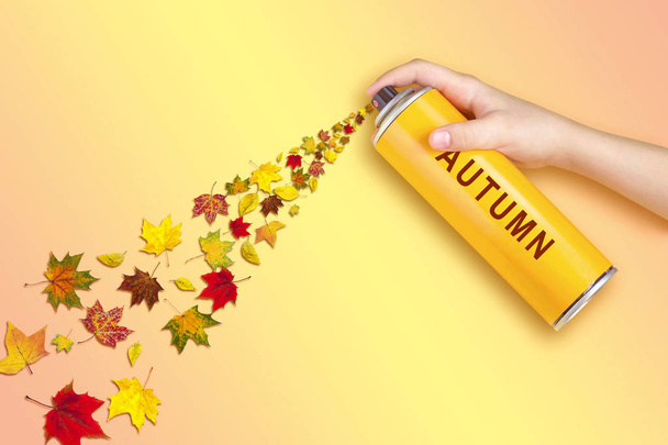 Gele bladeren vlucht uit spray kan met inscriptie: herfst. Pastel verloop achtergrond. Minimalistische stijl. Creatief idee, verbeelding en fantasie. Originele herfst concept - Foto, afbeelding