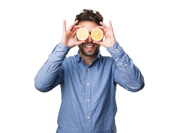 nuori mies peittää silmänsä sitruunat eristetty valkoisella pohjalla
 - Valokuva, kuva